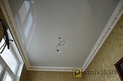 Глянцевый натяжной потолок в помещение гостиной комнаты (освещение: люстра)