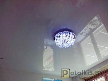 Глянцевый натяжной потолок белого цвета (освещение: люстра, материал: пвх)